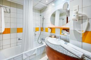 a bathroom with a sink and a tub at Hunguest Hotel Pelion in Tapolca