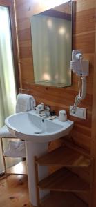 uma casa de banho com um lavatório branco e um espelho. em Balneario Acuña em Caldas de Reis