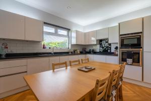 a large kitchen with a wooden table and chairs at Craigey Beach Home in Edinburgh