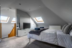 a bedroom with a bed and a tv and skylights at Craigey Beach Home in Edinburgh