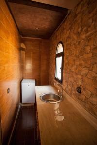 Un baño con lavabo y pared de piedra. en Toubkal appart hotel, en Tahannout