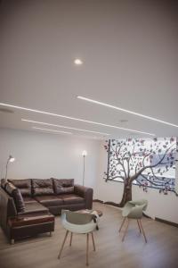 馬尼薩萊斯的住宿－Apartahotel La Arboleda HC，客厅配有沙发和树壁画