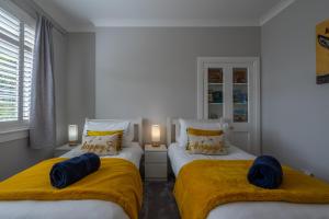 a bedroom with two beds with yellow blankets at Craigey Beach Home in Edinburgh