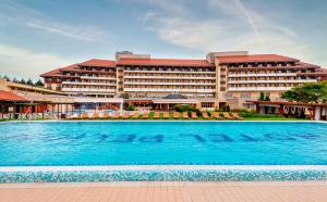 a hotel with a swimming pool in front of a building at Hunguest Hotel Pelion in Tapolca