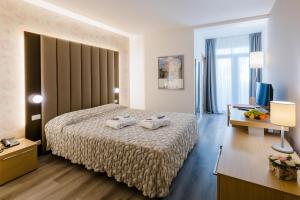 Una habitación de hotel con una cama con toallas. en Hotel Mioni Royal San, en Montegrotto Terme