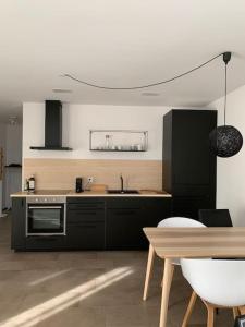 a kitchen with black appliances and a wooden table at Studio Apartment am Bodensee - modern und stilvoll in Ermatingen