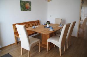 a dining room table with chairs and a wooden table at Ferienwohnung Loretta in Hergatz