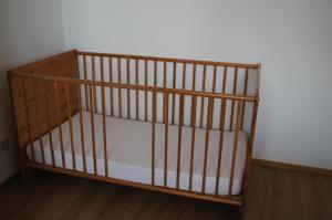 a wooden crib in a corner of a room at Ferienwohnung Loretta in Hergatz