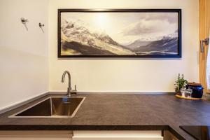 a kitchen with a sink and a painting on the wall at Ferienwohnung Kuppelwies 363 in Ultimo