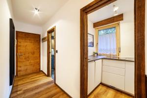 a kitchen with white cabinets and a wooden door at Ferienwohnung Kuppelwies 363 in Ultimo