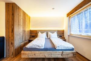 uma cama num quarto com uma parede de madeira em Ferienwohnung Kuppelwies 363 em Ultimo