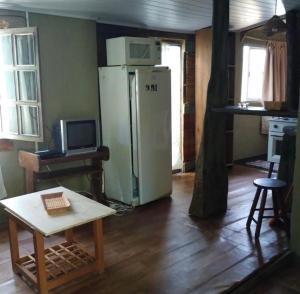 een keuken met een koelkast en een tafel in een kamer bij Apartamentos completos a metros del mar in Aguas Dulces