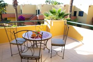 d'une table et de chaises sur un balcon avec des palmiers. dans l'établissement Oeste Tere by Best Holidays Fuerteventura, à Corralejo