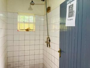 a bathroom with a blue door and a window at Yes Hostel in Fort Portal