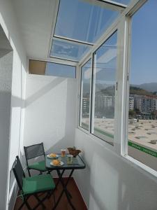 Una mesa pequeña y una silla en una habitación con ventana en Apartamento Oliveira, en Funchal