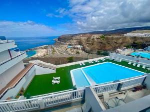 a building with a large swimming pool next to the ocean at Amadores Sunset Suite in Amadores