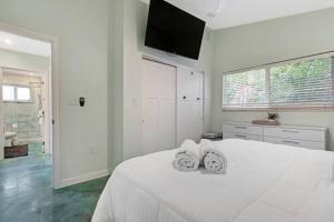 a white bedroom with a white bed with two towels at Heated Pool I Soundproof Home I Firepit I 630Mbps in Hollywood +39 photos