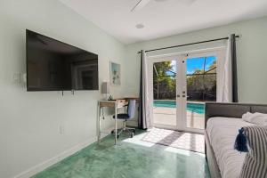 a bedroom with a bed and a desk and a television at Heated Pool I Soundproof Home I Firepit I 630Mbps in Hollywood