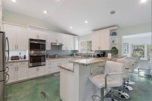 a large kitchen with white cabinets and green floors at Heated Pool I Soundproof Home I Firepit I 630Mbps in Hollywood