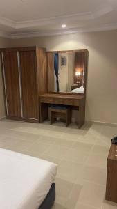 a bedroom with a mirror and a bed and a desk at واحة طيبة للشقق الفندقية in Al Madinah