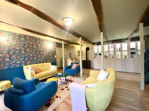 ein Wohnzimmer mit Sofas und Stühlen sowie einem Gemälde in der Unterkunft Maison Alfred et Agatha in Pleudihen-sur-Rance