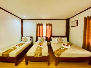 a room with two beds in a room at Sophias Beach Guest House in El Nido
