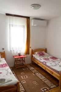 a room with two beds and a window and a table at Apartment R. Dermendzhiev in Melnik