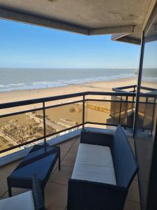 a balcony with two chairs and a view of the beach at luxurious apartment with sea view in Blankenberge