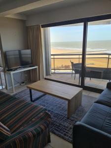 a living room with a view of the beach at luxurious apartment with sea view in Blankenberge