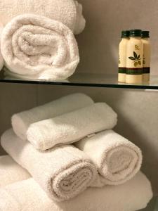 - deux serviettes blanches sur une étagère dans une salle de bains dans l'établissement Svevia Home, à Manfredonia
