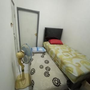 ein kleines Schlafzimmer mit einem Bett und einem Ventilator in der Unterkunft Sewa Rumah Harian 3 BR di Bandung,Kiaracondong in Bandung