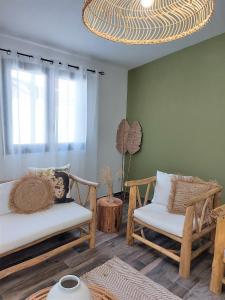 uma sala de estar com duas cadeiras e um lustre em Villa Couleur Nature em Salazie