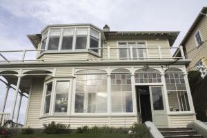 Cette maison blanche dispose de grandes fenêtres et d'une terrasse couverte. dans l'établissement BnB at Bidwill, à Wellington