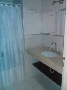 a bathroom with a sink and a shower curtain at TORRES DEL TUCUMAN I in San Miguel de Tucumán