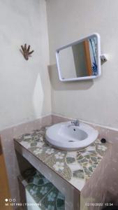 a bathroom with a sink and a mirror on the wall at Lung Soi Nguen Homstay Pang Oung in Pang Ung