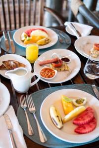 - une table en bois avec des assiettes de nourriture pour le petit-déjeuner dans l'établissement Saadani Safari Lodge, à Saadani