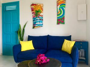 appartement privé ECO-RESPONSABLE, vue sur la mer des Caraibes et jardin clos, WiFi, à 2mn de la plage في سانت لوسي: أريكة زرقاء في غرفة المعيشة مع طاولة