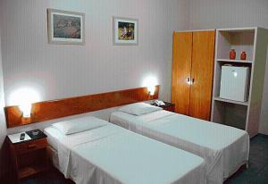 a hotel room with two beds and two cabinets at Pousada Abais in Aracaju