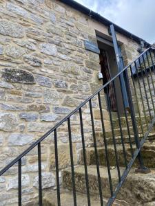 een stenen huis met een trap naar een deur bij The Brosterfield Suite - Brosterfield Farm in Bakewell