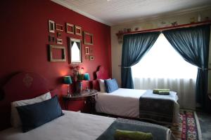 a red bedroom with two beds and a window at Rocks & Roses Farm stay in Lochiel