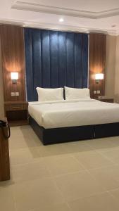 a bedroom with a large bed and two lamps at واحة طيبة للشقق الفندقية in Al Madinah