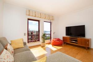 uma sala de estar com um sofá e uma televisão de ecrã plano em Lisboa Tejo Apartment @ Stay like a local at Algés em Cruz Quebrada