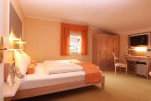 a bedroom with a bed and a desk and a television at Rabenauer Mühle "bed & breakfast" in Rabenau +40 photos