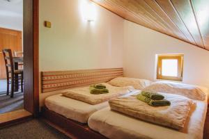 sypialnia z 2 łóżkami i zielonymi ręcznikami w obiekcie Haus Blueberry - Baranek Resorts w mieście Leogang