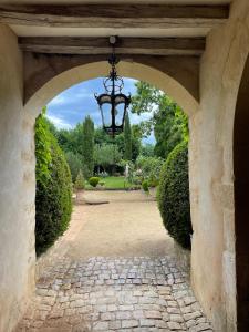 une arche menant à un jardin avec un lustre dans l'établissement Clos Saint Léonard, à Durtal