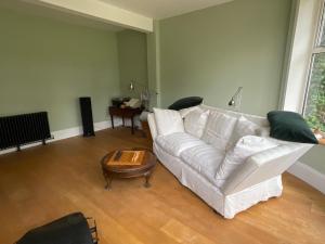 a living room with a white couch and a table at Luxury large coastal retreat near the sea in Deal