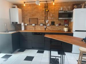 a kitchen with blue cabinets and a wooden counter top at Luxury large coastal retreat near the sea in Deal