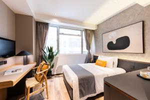 a hotel room with a bed and a desk at Dash Living on Prat in Hong Kong