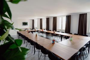 una sala de conferencias con mesas y sillas largas en Schlafladen Hildesheim Hotel & Hostel en Hildesheim