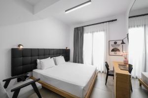 Schlafzimmer mit einem großen weißen Bett und einem Schreibtisch in der Unterkunft Pillow urban stay in Thessaloniki